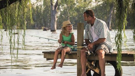 A father and daughter fishing on a jetty